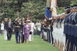 Queen Elizabeth II and President  George H.W. Bush,  along with Commander of Troops Col. Barrie Zais, left, review the troops after the Queen's arrival at the White House on Tuesday, May 14, 1991 in Washington.   The Queen is to spend four days in Washington. (AP Photo/Barry Thumma)