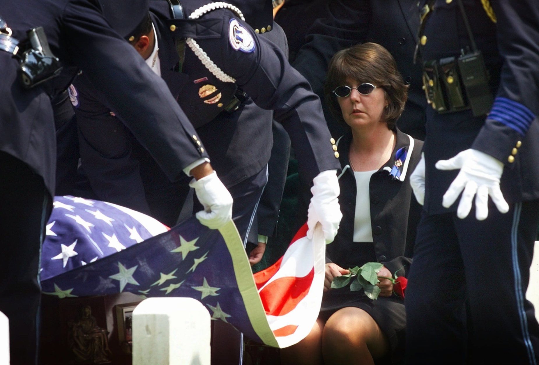 Evelyn Gibson, the wife of slain Capitol Hill police officer John Gibson, holds a rose as an American flag is folded to be presented to her Thursday July 30, 1998 at graveside ceremonies at Arlington National Cemetery in Arlington, Va. Gibson and fellow Capitol Hill police officer Jacob Chestnut were killed on Friday July 24, 1998 when a gunman burst into the Capitol. (AP Photo/Doug Mills)