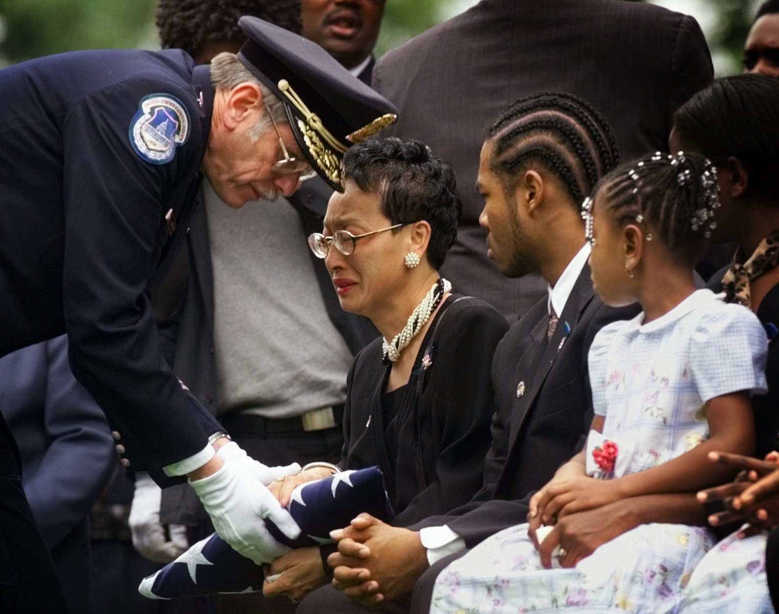 Capitol Police Chief Gary Abrecht presents the flag that draped the casket of Capitol police officer Jacob Chestnut to his widow Wendy Chestnut during funeral services at Arlington National Cemetery in Arlington, Va. Friday, July 31,1998. Chestnut, along with fellow officer John Gibson were shot and killed last week when a gunman burst through a security barrier on Capitol Hill. (AP Photo/Doug Mills)