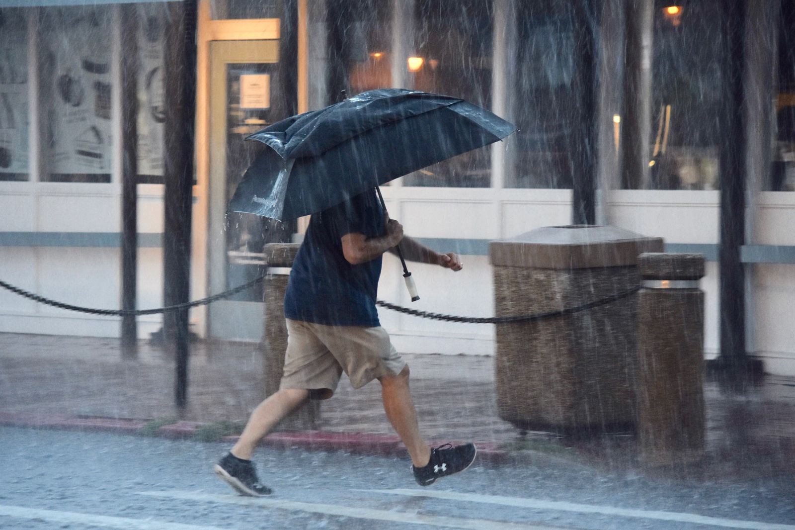 A man near City Dock in Annapolis, Maryland, tries to stay dry in the pouring rain. (WTOP/Dave Dildine)