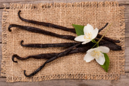 Vanilla sticks with flower and leaf on sackcloth.