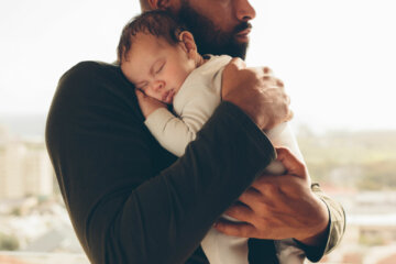 Newborn baby boy in his father's arms