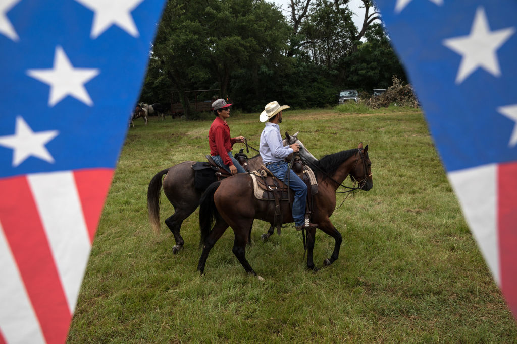 ROUND TOP, TX - JULY 04: Men on horseback ride through a field after taking part in the 168th annual Round Top Fourth of July Parade on July 4, 2018 in Round Top, Texas. The Round Top community's Fourth of July celebration started in 1851 and is known as the longest running Fourth of July celebration west of the Mississippi. (Photo by Tamir Kalifa/Getty Images)
