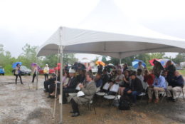 Attendees dodge raindrops at the Long Bridge Park aquatics center groundbreaking. (ARLNow.com)