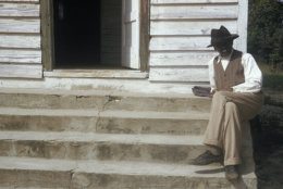 In this 1950's photo released by the National Archives, a man included in a syphilis study sits on steps in front of of a house in Tuskegee, Ala. For 40 years starting in 1932, medical workers in the segregated South withheld treatment for unsuspecting men infected with a sexually transmitted disease simply so doctors could track the ravages of the horrid illness and dissect their bodies afterward. Finally exposed in 1972, the study ended and the men sued, resulting in a $9 million settlement. (National Archive via AP)