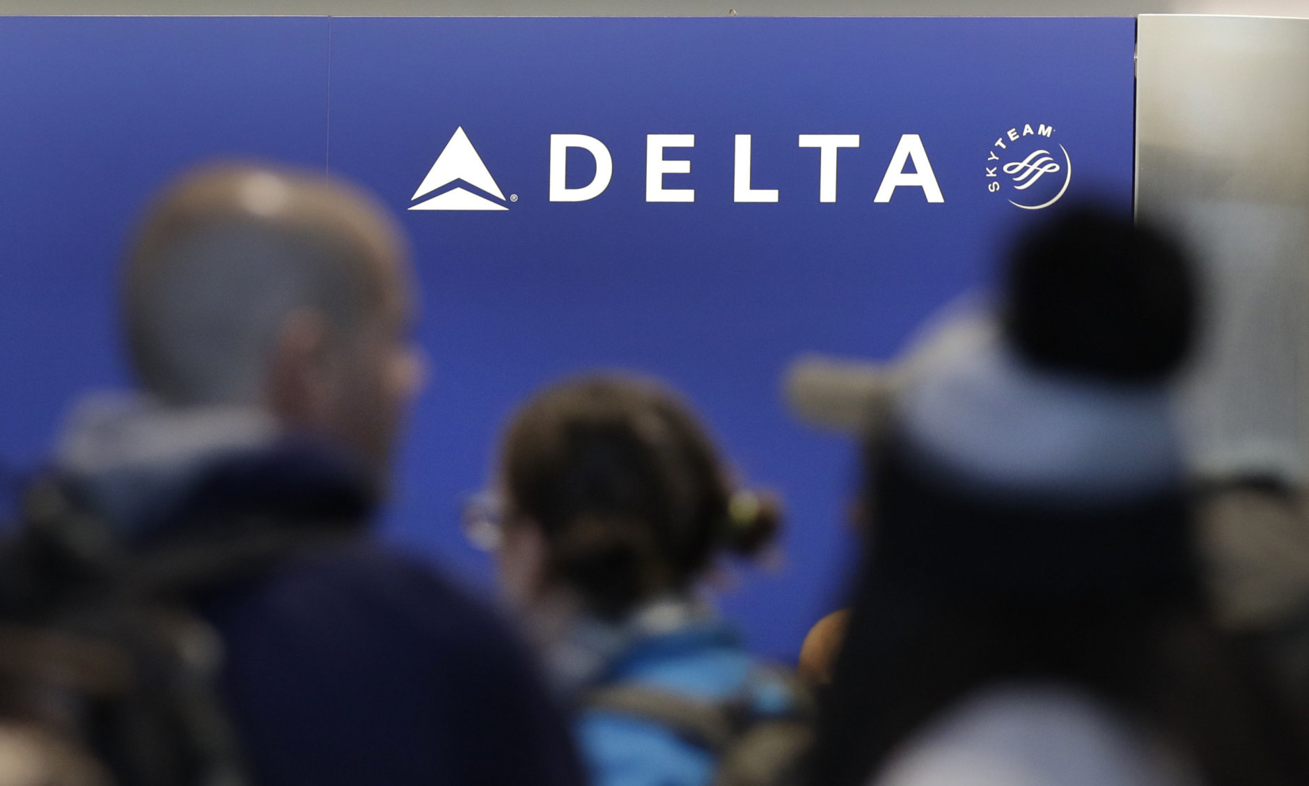 Travelers wait in line at the Delta Air Lines counter at Logan International Airport in Boston, Monday, Jan. 8, 2018. (AP Photo/Charles Krupa)