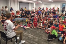 Washington Nationals closing pitcher Sean Doolittle reads to a group of kids who are taking part in this year's Summer Reading Challenge. (WTOP/John Domen)