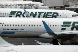 ADDS CLARIFICATION- FILE - In this May 15, 2017, photo, Frontier Airlines jetliners sit stacked at gates on the A Concourse at Denver International Airport in Denver. The U.S. government has fined Frontier Airlines $1.5 million for keeping passengers stuck on a dozen grounded aircraft for sitting on the tarmac for more than three hours during a snowstorm at the Denver airport last December. But the federal Department of Transportation said Friday, Sept. 15, 2017, it will forgive $900,000 of that because of compensation the airline says it paid to passengers. (AP Photo/David Zalubowski, File)