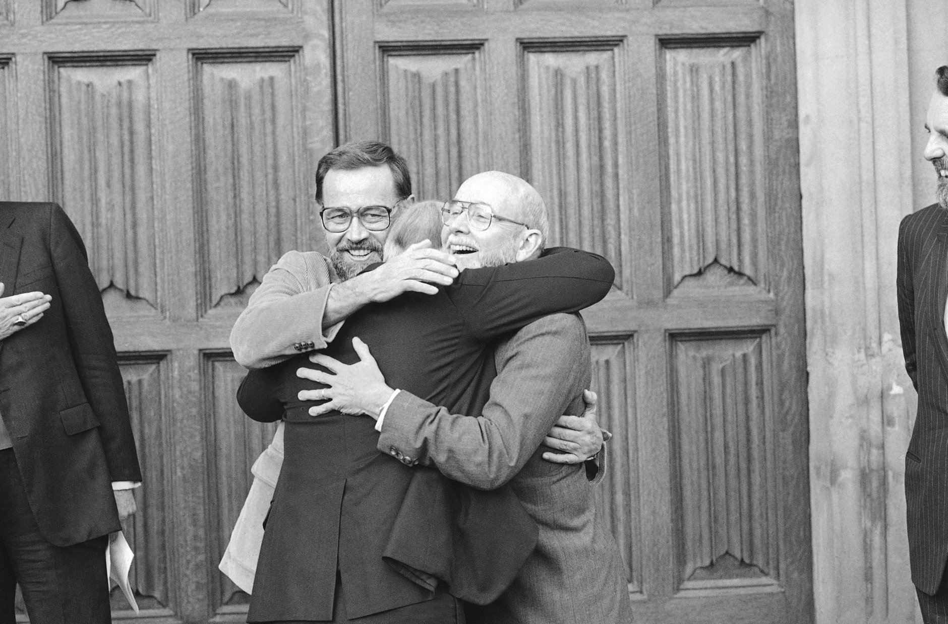 Three Americans formerly held as hostages in Lebanon embrace on being reunited in London, Nov. 17, 1986. The trio, from left, David Jacobsen, Rev. Lawrence Martin Jenco and Rev. Benjamin Weir, were preparing to meet Church of England envoy Terry Waite. (AP Photo/Gerald Penny)