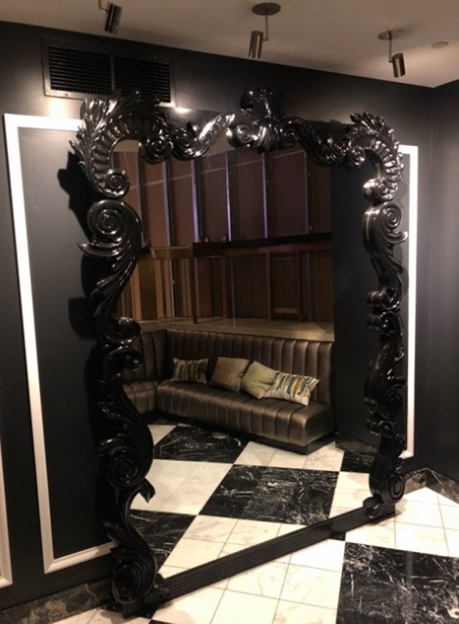 An ornate oversized framed mirror with black finish. (Courtesy Rasmus Auctions)