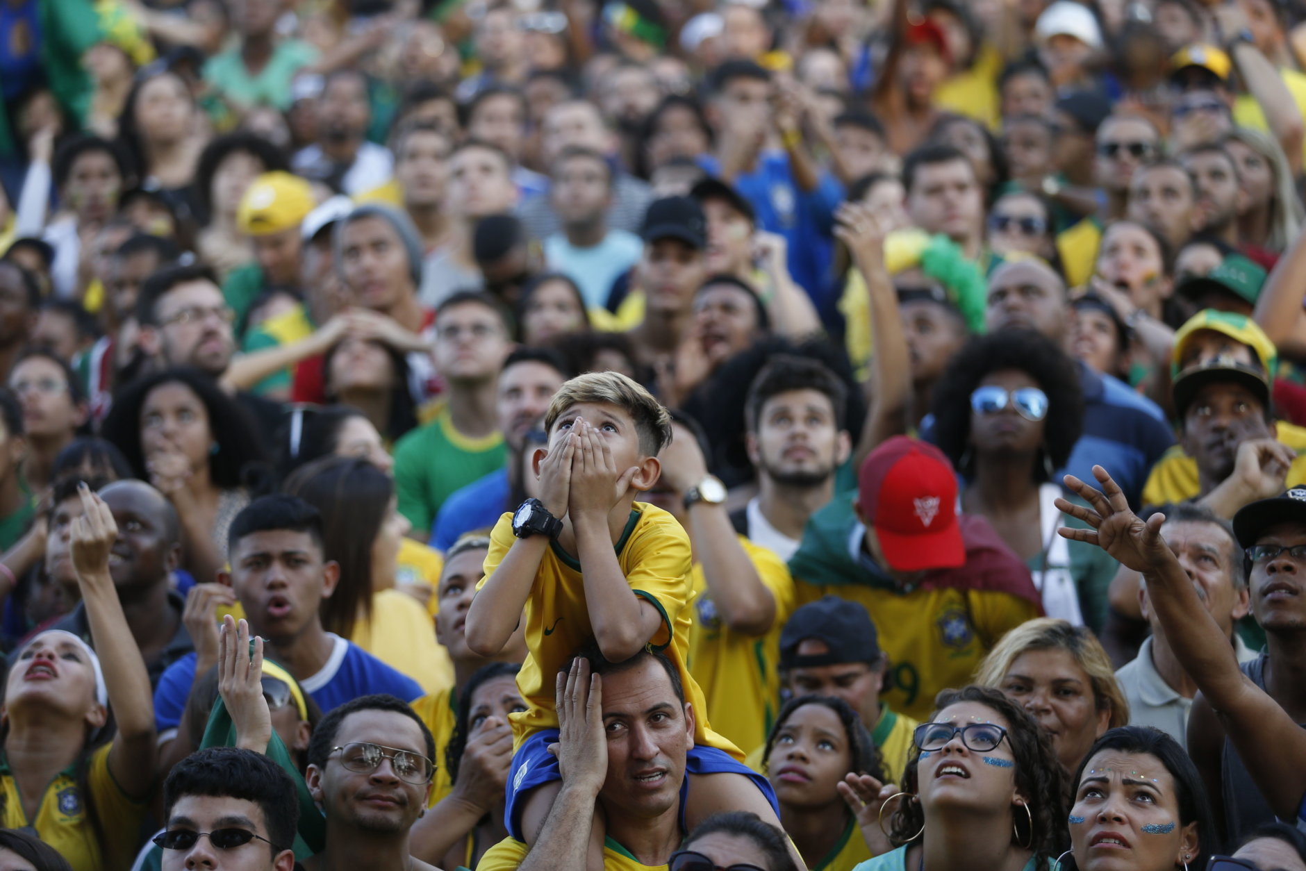 Worried Brazil soccer fans watch a live telecast of the Brazil vs. Belgium World Cup quarter finals soccer match, in Rio de Janeiro, Brazil, Friday, July 6, 2018. (AP Photo/Silvia Izquierdo)