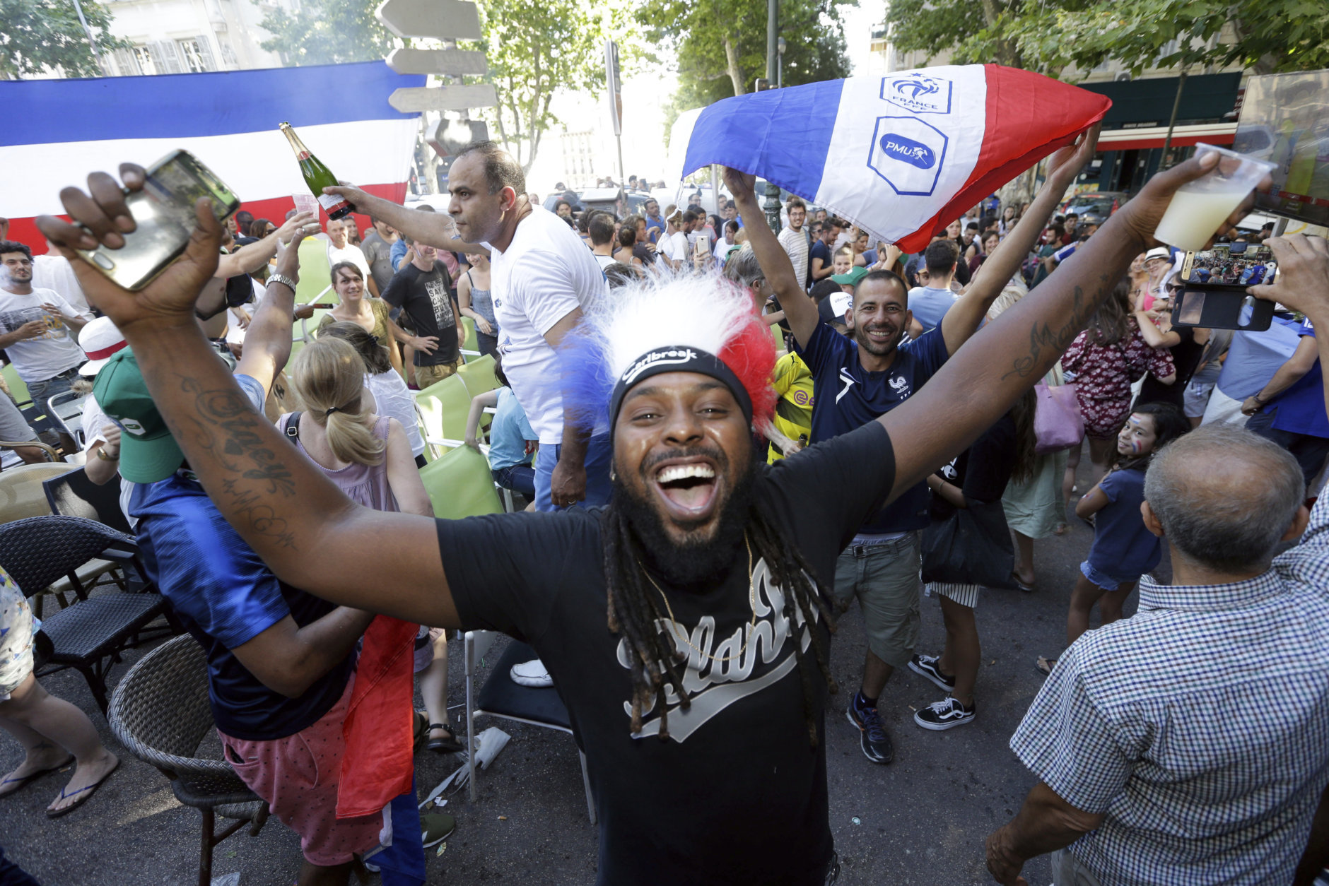 Supporters of France celebrate the victory ot their team against Uruguay during their quarterfinal match at the 2018 soccer World Cup played in Russia, as they watch a live broadcast of the match in a bar, in Marseille, southern France, Friday, July 6, 2018. (AP Photo/Claude Paris)