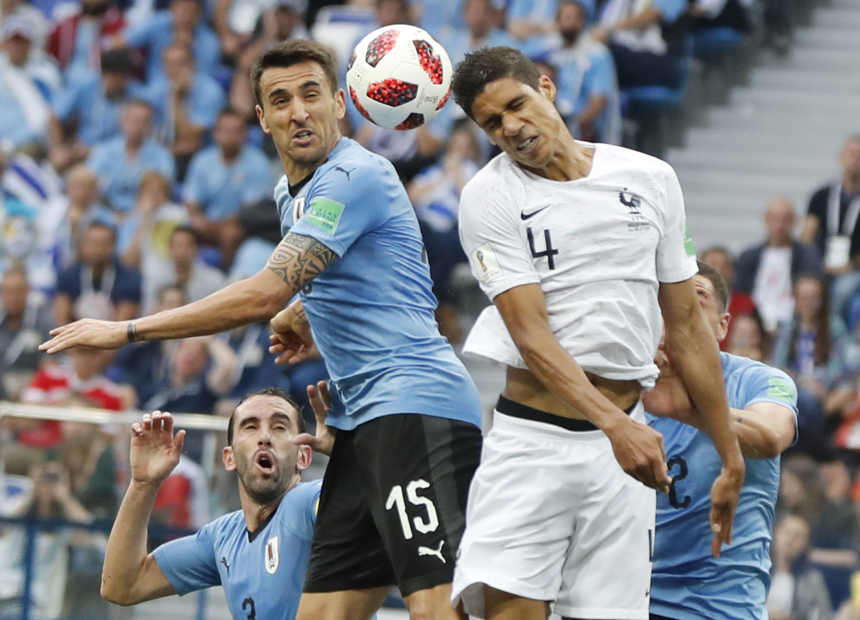France's Raphael Varane, center right, and Uruguay's Matias Vecino, center left, challenge for the ball during the quarterfinal match between Uruguay and France at the 2018 soccer World Cup in the Nizhny Novgorod Stadium, in Nizhny Novgorod, Russia, Friday, July 6, 2018. (AP Photo/Petr David Josek)