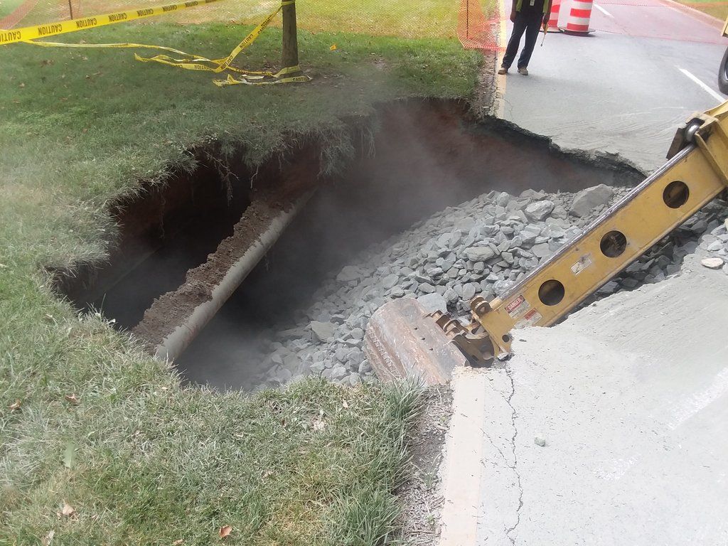 The sinkhole was caused by a pipe that was designed to take rainwater to a nearby creek failed due to rust. (WTOP/Ralph Fox)