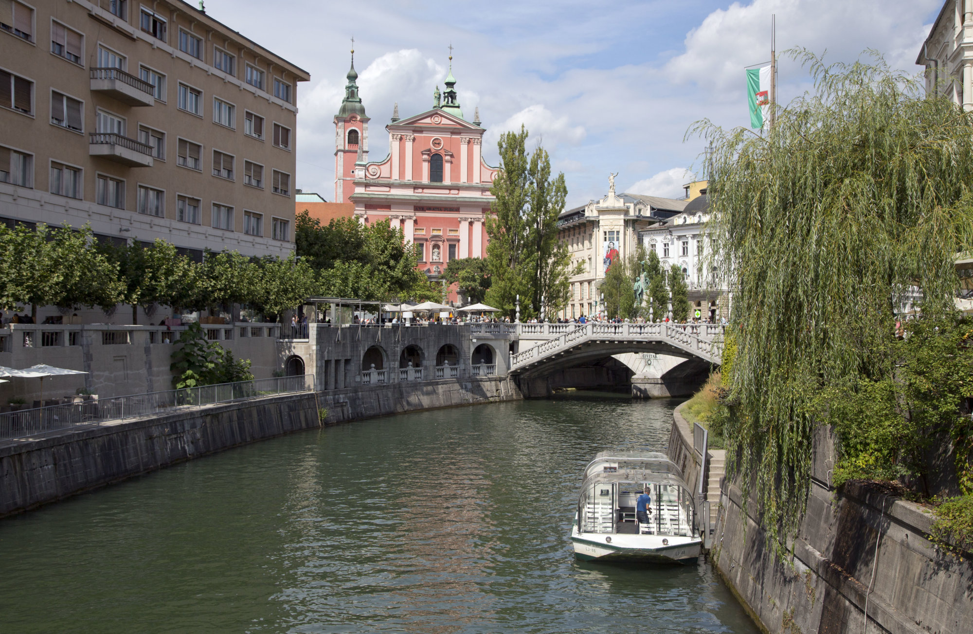 FILE - In this Aug. 12, 2016 file photo, tourists and residents walk across Tromostovje bridge in downtown Ljubljana, Slovenia. The tiny European nation of Slovenia is getting an outsize share of attention lately. Not only has Melania Trump, wife of U.S. President-elect Donald Trump. given her native country a boost of recognition, but Slovenia’s also in the midst of a tourism boom. (AP Photo/Darko Bandic, File)