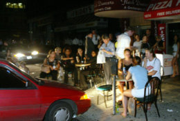 Patrons eat and drink outside Leon's Pizza in midtown Manhattan in New York, under the lights of a parked car, during a blackout, Thursday, Aug. 14, 2003. Night descended on New York shortly after 4  p.m., Thursday, when power went out throughout the five boroughs and most of its suburbs.  (AP Photo/Joe Kohen)