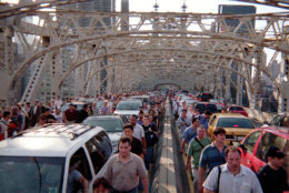Commuters walk over the Queensborough Bridge with traffic stopped in gridlock in New York, Thursday, August 14, 2003 during a massive blackout which knocked out power in most of the Northeastern United States.  (AP Photo/Sean M. Thompson)