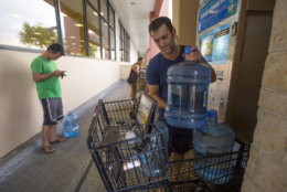 HONOLULU, HI - AUGUST 22: Wenkai He, left, waits his turn to fill up his 3 gallon water jug for just $1.50, while Alex Krivoulian fills three times as many water jugs at Safeway on Kapahulu in preparation for Hurricane Lane on Wednesday, August 22, 2018 in Honolulu, Hawaii. Hurricane Lane is a high-end Category 4 hurricane and remains a threat to the entire island chain. (Photo by Kat Wade/Getty Images)