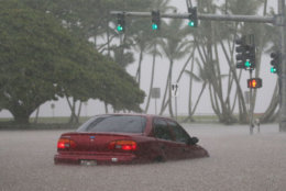 HILO, HI - AUGUST 23:  A car is stuck partially submerged in floodwaters from Hurricane Lane rainfall on the Big Island on August 23, 2018 in Hilo, Hawaii. Hurricane Lane has brought more than a foot of rain to some parts of the Big Island which is under a flash flood warning.  (Photo by Mario Tama/Getty Images)
