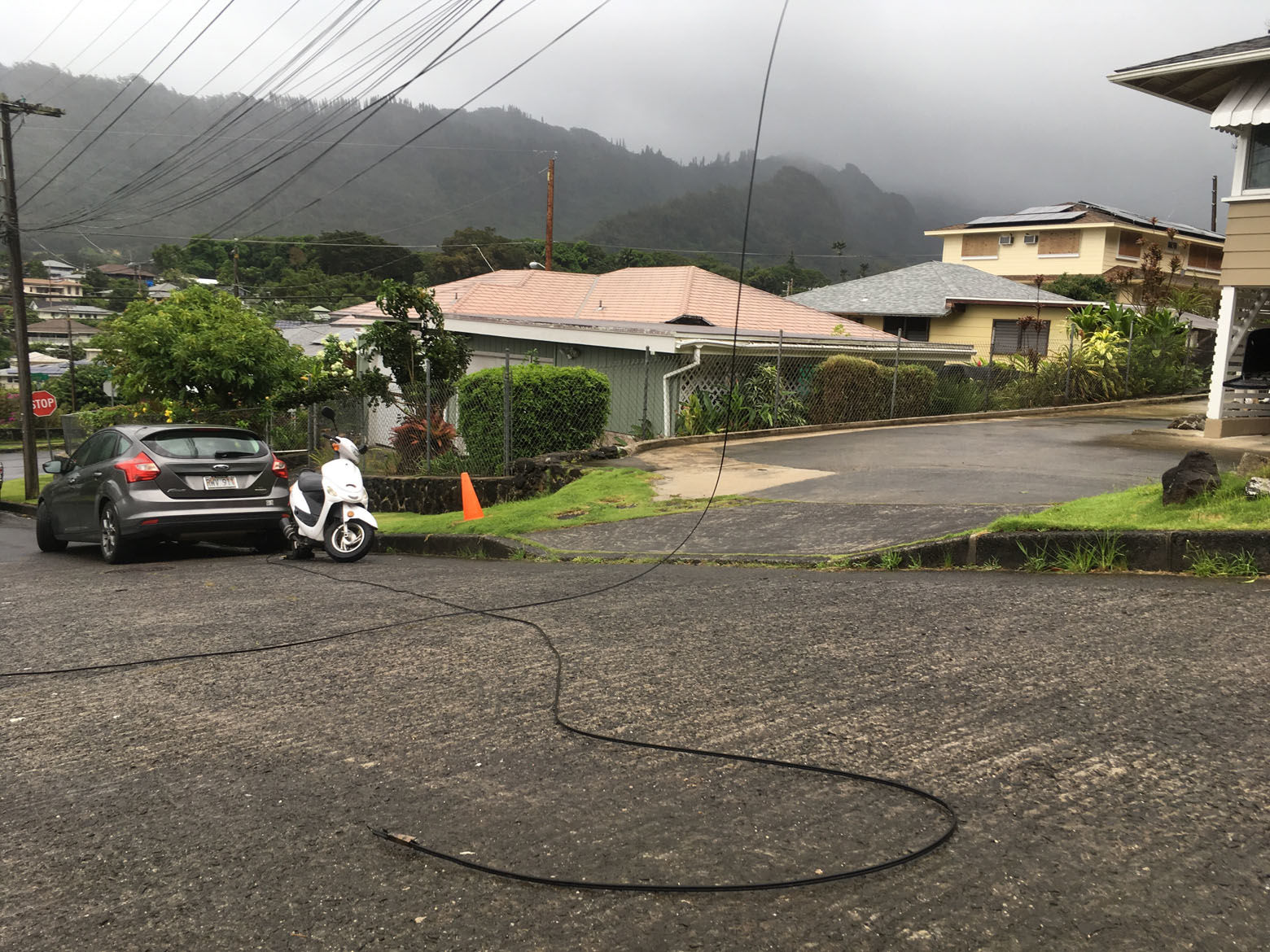 A utility line lays in the street in the Nuuanu neighborhood of Honolulu, Friday, Aug. 24, 2018, as Hurricane Lane approaches. Hurricane Lane barreled toward Hawaii on Friday, dumping torrential rains that caused flooding on the Big Island as people stocked up on supplies and piled sandbags to shield oceanfront businesses against the increasingly violent surf.  (AP Photo/Caleb Jones)