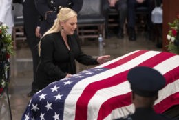 Meghan McCain reaches out to touch the flag-draped casket bearing the remains of her father, Sen. John McCain, R-Ariz., during a farewell ceremony in the Capitol Rotunda, Friday, Aug. 31, 2018, in Washington.  (AP Photo/J. Scott Applewhite)