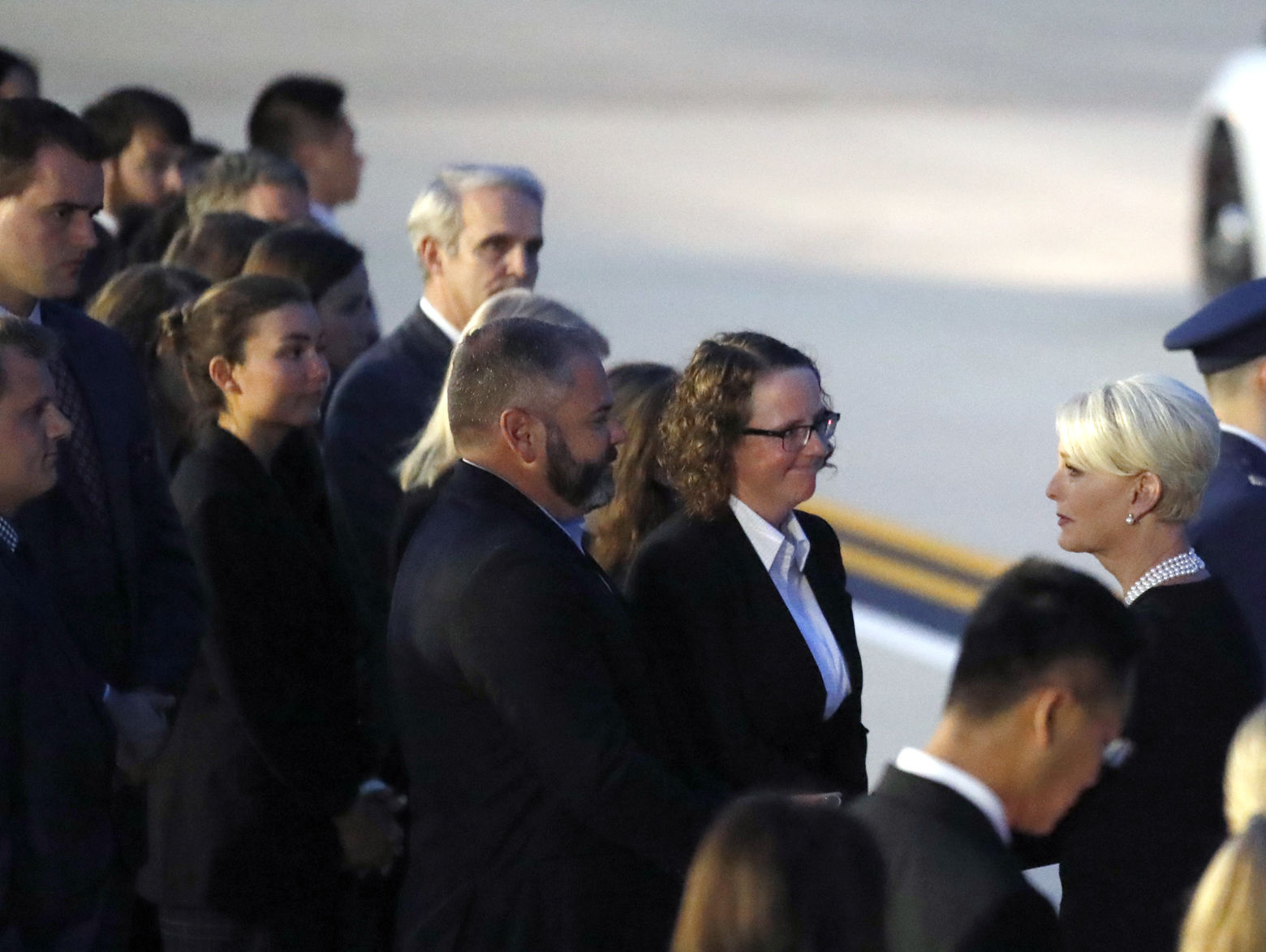 Cindy McCain, right, the wife of Sen. John McCain, R-Ariz., greets current and former staff members of McCain, Thursday, Aug. 30, 2018, at Andrews Air Force Base, Md. (AP Photo/Alex Brandon)
