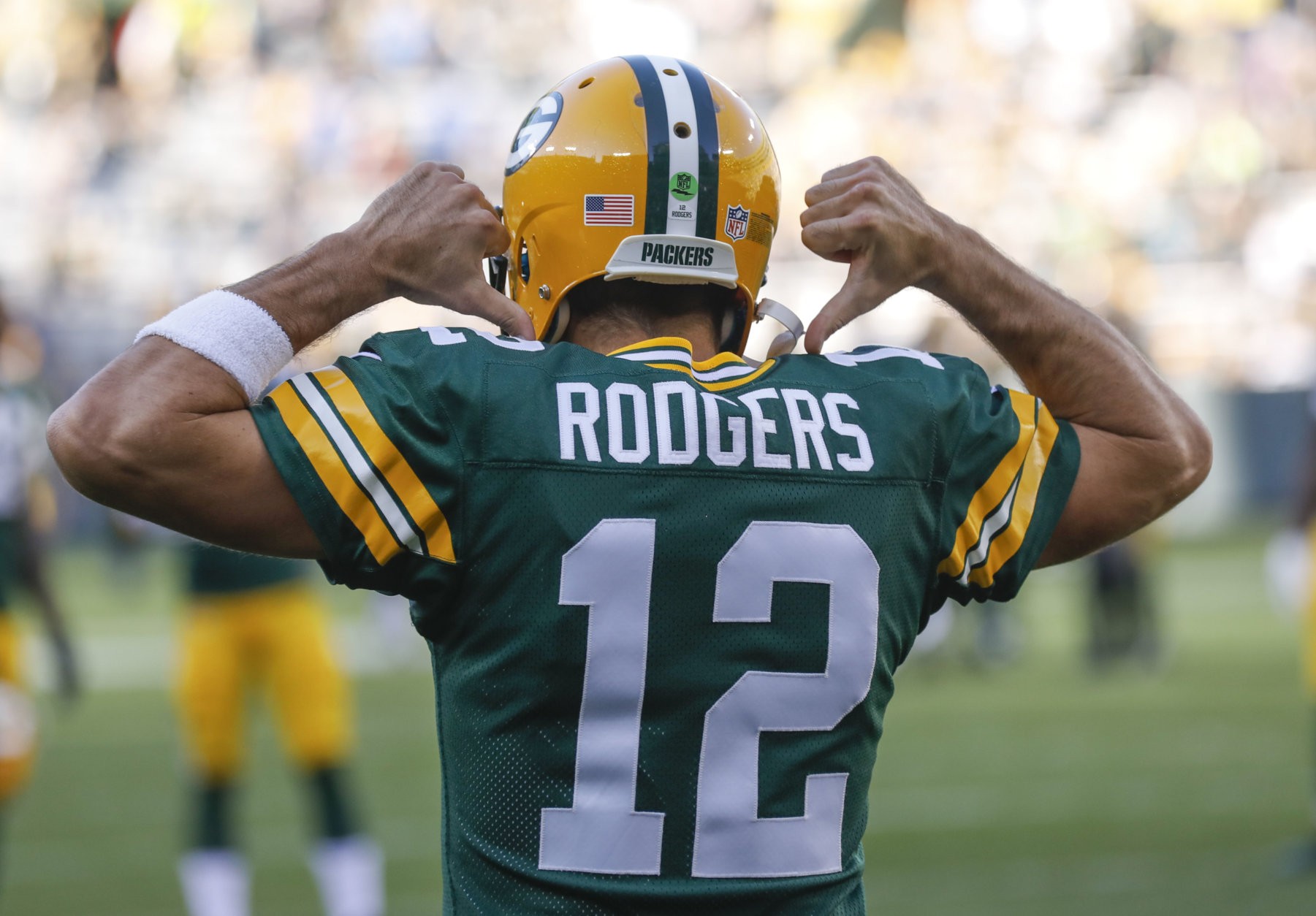 Green Bay Packers' Aaron Rodgers points to his back before a preseason NFL football game against the Los Angeles Rams Thursday, Aug. 31, 2017, in Green Bay, Wis. (AP Photo/Jeffrey Phelps)