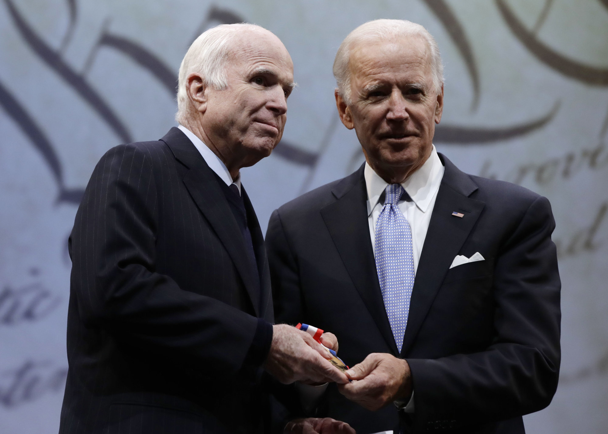 Sen. John McCain, R-Ariz., receives the Liberty Medal from Chair of the National Constitution Center's Board of Trustees, former Vice President Joe Biden in Philadelphia, Monday, Oct. 16, 2017. The honor is given annually to an individual who displays courage and conviction while striving to secure liberty for people worldwide. (AP Photo/Matt Rourke)