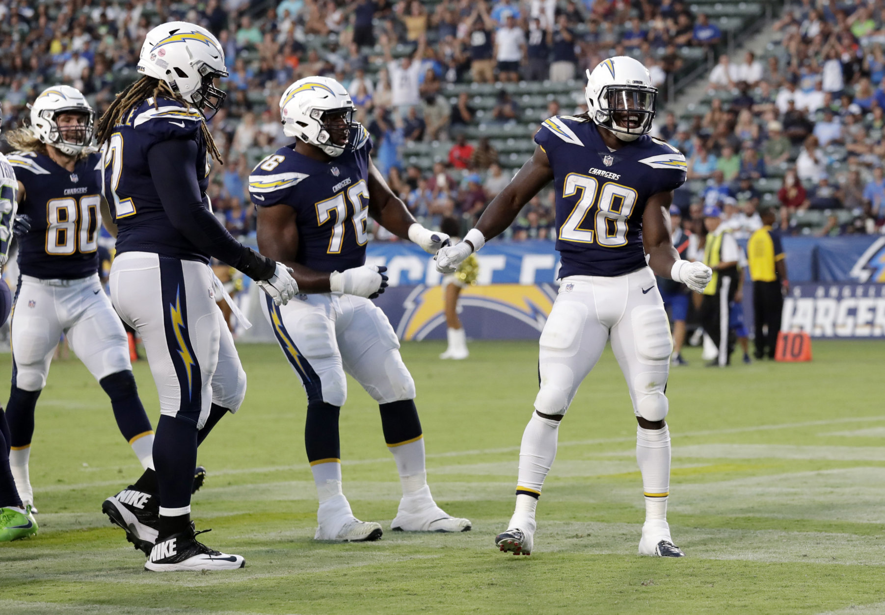 Los Angeles Chargers running back Melvin Gordon (28) celebrates after scoring a rushing touchdown against the Seattle Seahawks during the first half of an NFL preseason football game Saturday, Aug. 18, 2018, in Carson, Calif. (AP Photo/Gregory Bull)