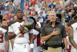 Tampa Bay Buccaneers head coach Dirk Koetter and quarterback Jameis Winston (3) stand for the national anthem before a preseason NFL football game against the Tennessee Titans Saturday, Aug. 18, 2018, in Nashville, Tenn. (AP Photo/Mark Zaleski))
