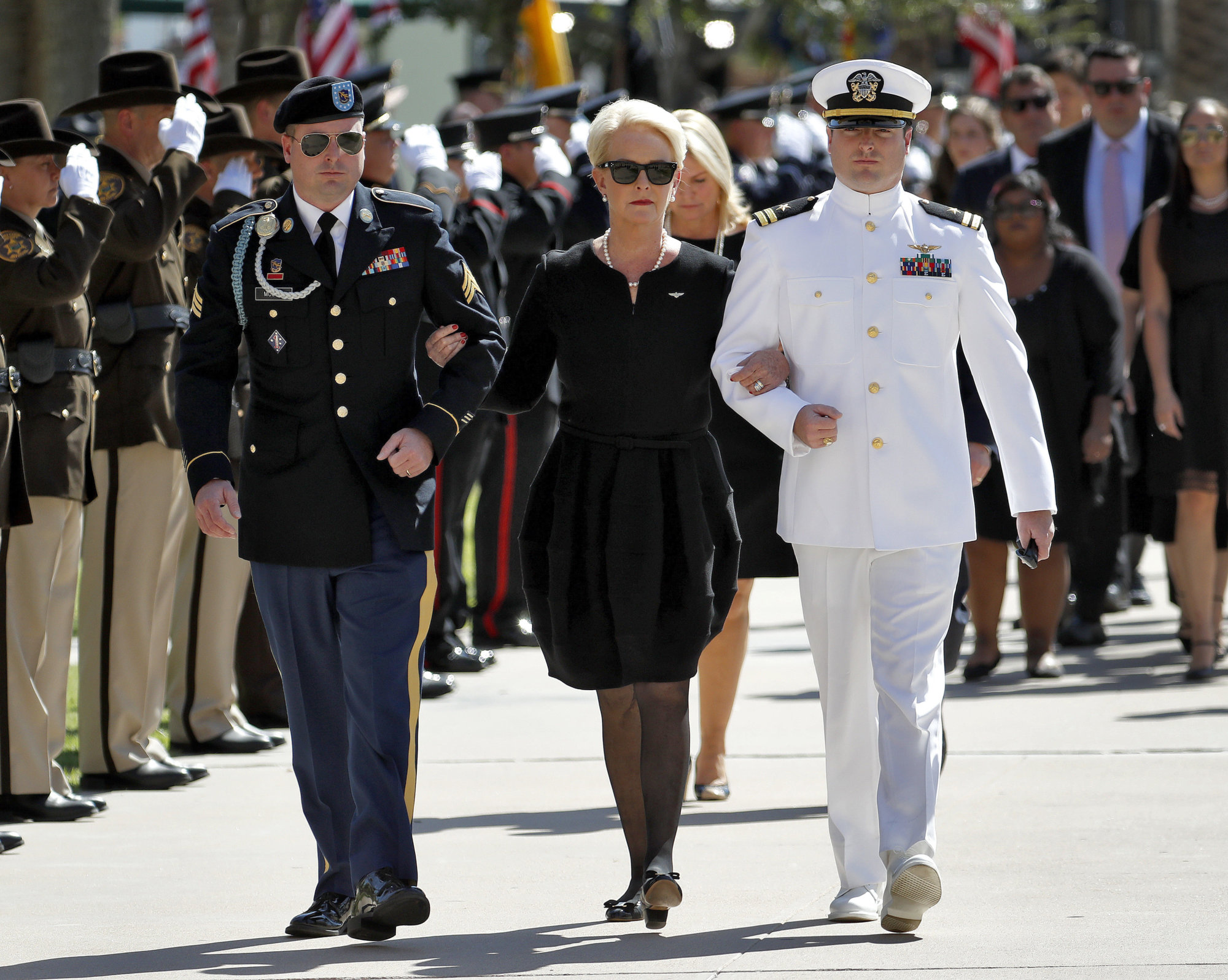 Cindy McCain, escorted by sons, Jack McCain, right, and Jimmy McCain, follow behind military personal carrying the casket of Sen. John McCain, R-Ariz., into the Capitol rotunda for a memorial service, Wednesday, Aug. 29, 2018, at the Capitol in Phoenix. (AP Photo/Matt York)