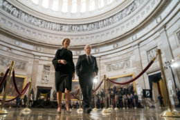 Senate Majority Leader Mitch McConnell of Ky., center, accompanied by an aide, walks through the Rotunda before the casket of Sen. John McCain, R-Ariz., lies in state at the U.S. Capitol, Friday, Aug. 31, 2018, in Washington. (AP Photo/Andrew Harnik, Pool)