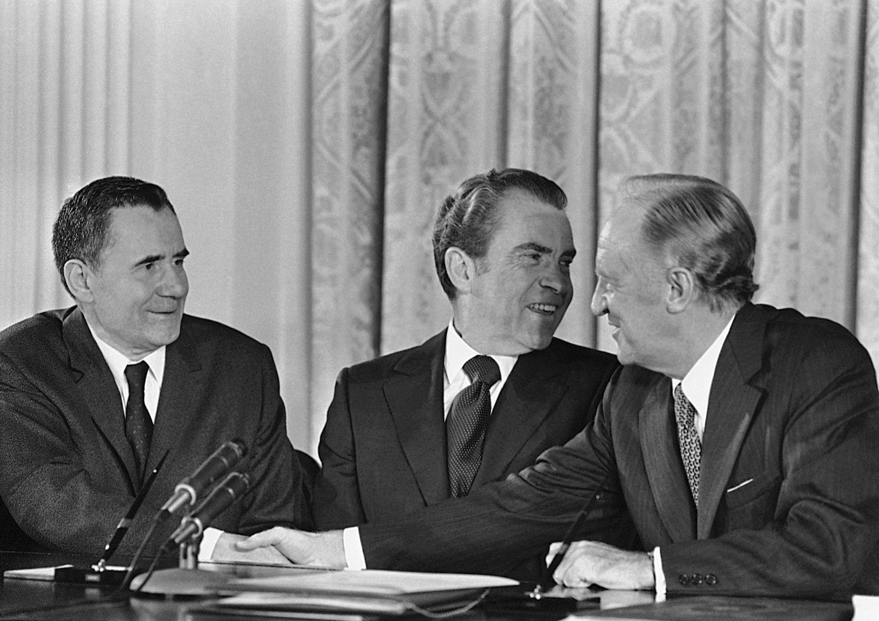U.S. President Richard Nixon after signing the formal proclamation declaring the United States and Soviet Union have bound themselves by treaty to curb their anti ballistic-missile activities. He announced a souvenir pen would be given to all participants at the ceremony in the White House East Room, Washington on Oct. 3, 1972. At left is Soviet Foreign Minister Andrei Gromyko. Man at right is unidentified. (AP Photo/Henry Burroughs)
