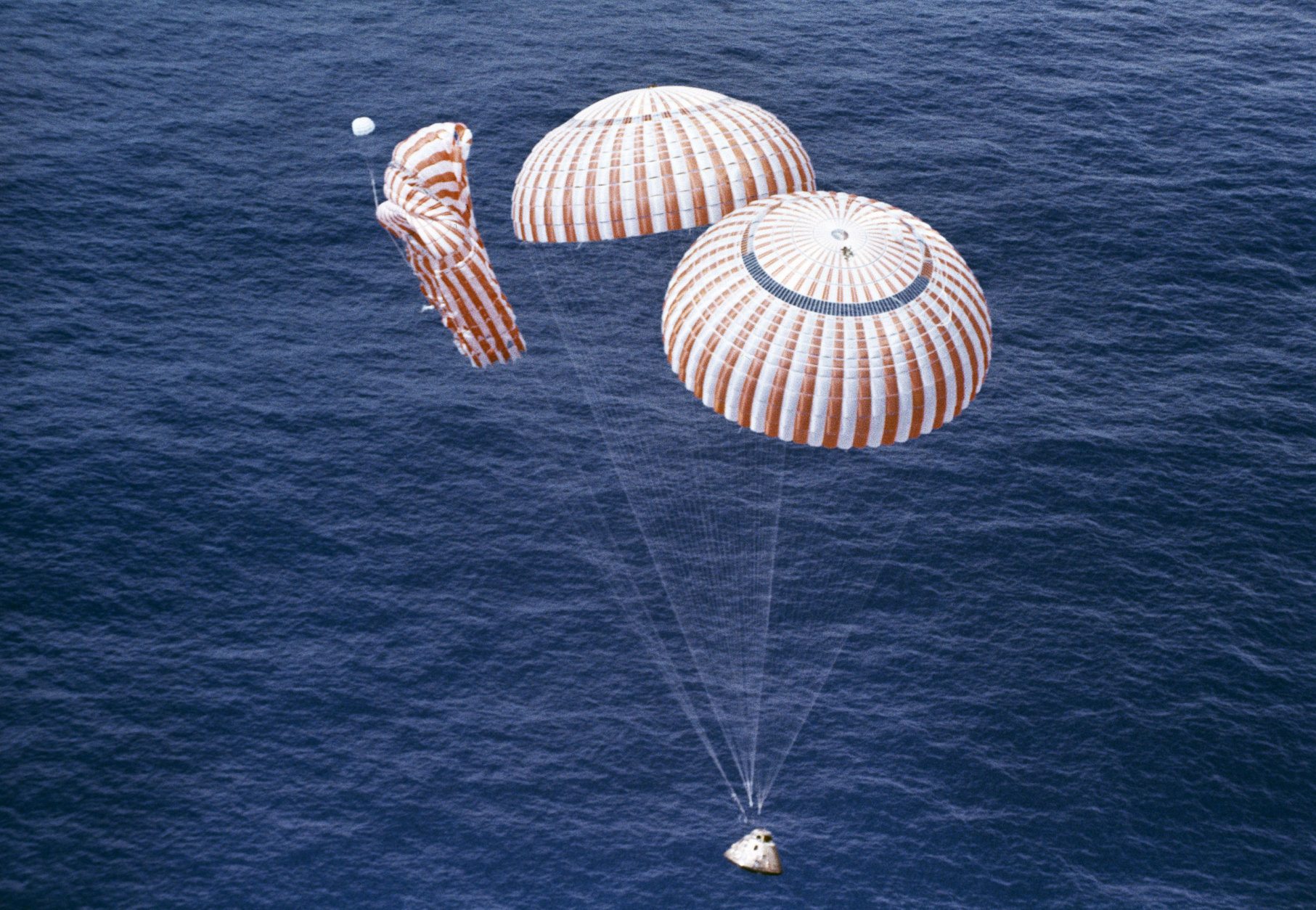 The Apollo 15 spacecraft glided to a safe splashdown in the Pacific Ocean on two of its three parachutes as Astronauts David R. Scott, Alfred M. Worden and James Irwin completed their 12-day lunar mission. The third parachute collapsed, but did not endanger the astronauts, who completed this nations most ambitious lunar mission to date. Splashdown took place at 4:46 p.m. EDT; 333 miles north of Hawaii, August 7, 1972, and 295 hours after the astronauts were launched from the Kennedy Space Center. (AP Photo)