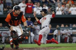 BALTIMORE, MD - AUGUST 11: Mookie Betts #50 of the Boston Red Sox scores a run on a single by Brock Holt #12 (not pictured) in the ninth inning against the Baltimore Orioles during game two of a doubleheader at Oriole Park at Camden Yards on August 11, 2018 in Baltimore, Maryland. (Photo by Patrick McDermott/Getty Images)