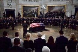 The flag-draped casket of Sen. John McCain, R-Ariz., lies in state in the U.S. Capitol Rotunda Friday, Aug. 31, 2018, in Washington. In the foreground is Cindy McCain and Vice President Mike Pence. (Kevin Dietsch/Pool Photo via AP)