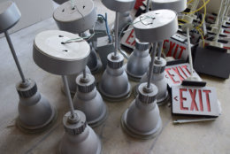 These light fixtures and emergency signs will soon have a new home in the WTOP space. (WTOP/Teta Alim)