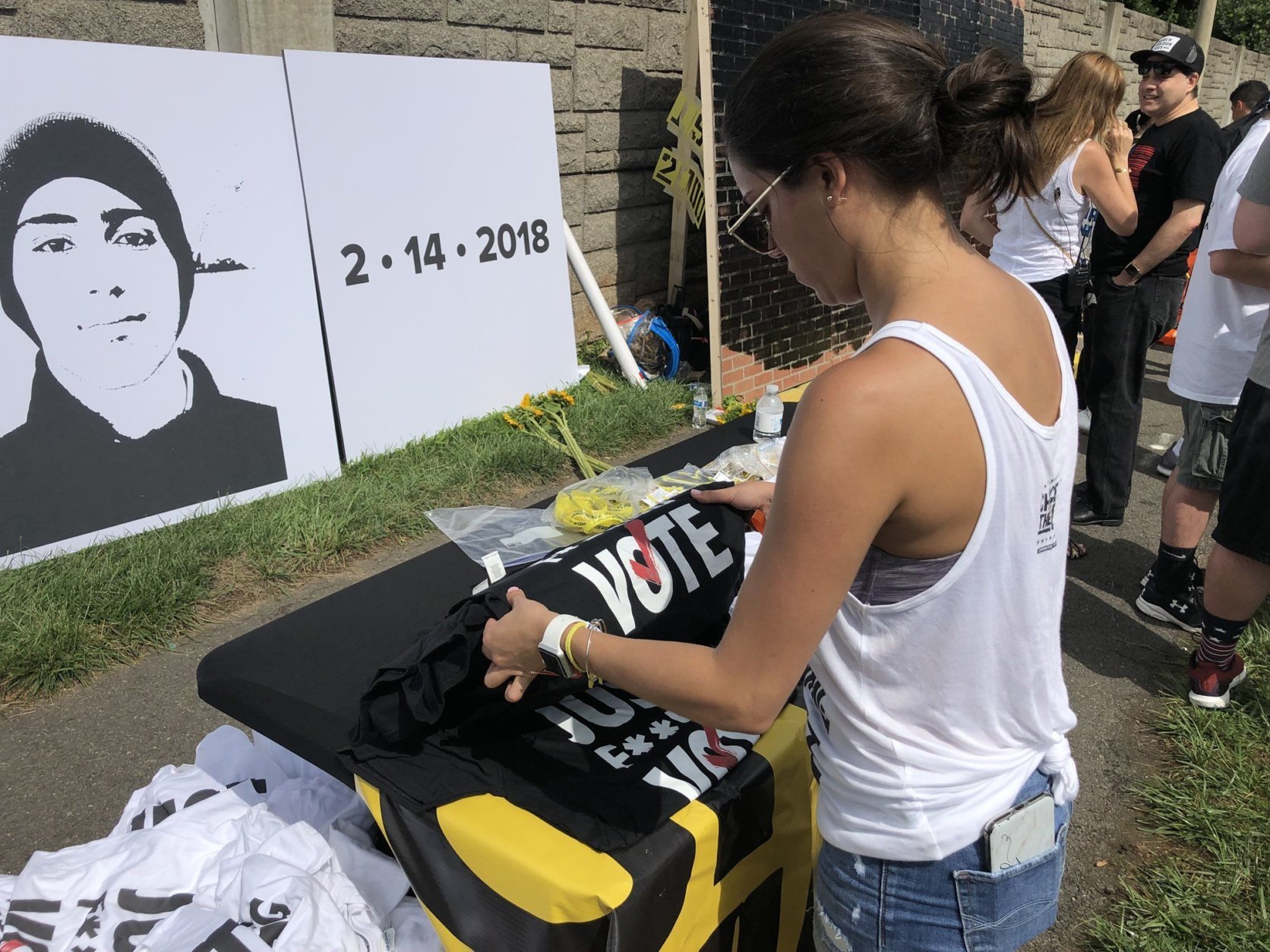 A rally-goer looks at a shirt reading "vote"" across the street from the NRA. (WTOP/Melissa Howell)
