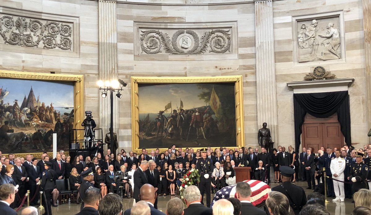 Senators Mitch McConnell and Chuck Schumer lay a wreath at John McCain's casket in the Capitol Rotunda. (WTOP/Chris Cioffi)