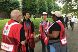 Volunteers with the American Red Cross coordinate to assist people  in line for the Rotunda who may be struggling in the late-summer heat. (WTOP/Kristi King)