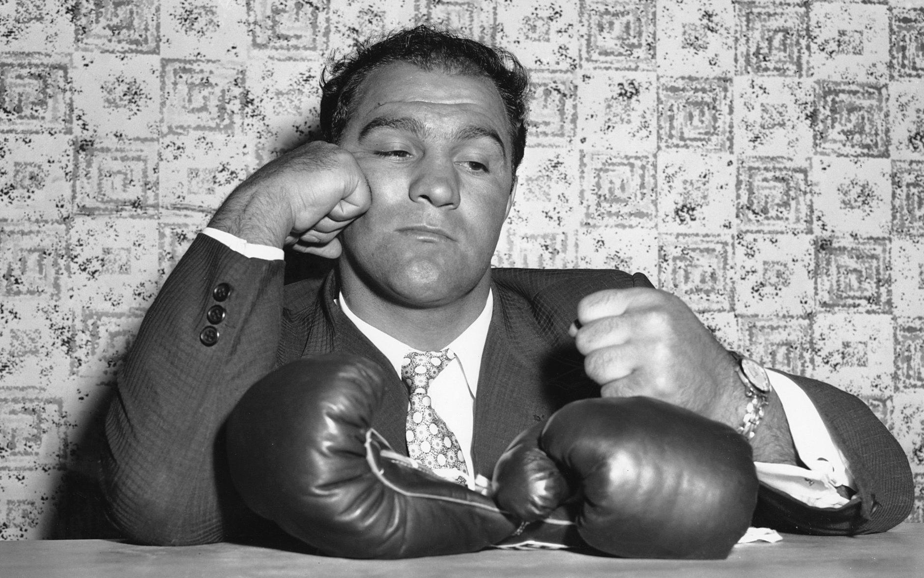 FILE  - In this April 27, 1956 file photo, World heavyweight champion Rocky Marciano gestures at a new conference in New York after announcing his retirement from boxing. Marciano had been the world heavyweight champion for four years and won all 49 of his fights _ 43 by knockout _ when he retired in 1956 at the age of 32. The American wanted to spend more time with his family. (AP Photo, File)