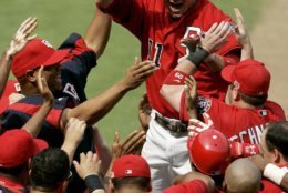 Washington Nationals' Ryan Zimmerman, center-facing camera,  celebrates his game-winning three-run home run with teammates at home plate in the bottom of the ninth inning of a baseball game against the Florida Marlins, Tuesday, July 4, 2006, in Washington. The Nationals won 6-4. Players also seen include, Jose Vidro, (3), Daryle Ward (31) and Marlon Byrd, (25).  (AP Photo/Haraz N. Ghanbari)