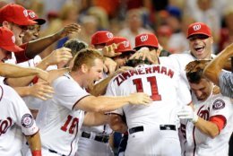 WASHINGTON, DC - JULY 26:  Ryan Zimmerman #11 of the Washington Nationals is mobbed by teammates after hitting the game winning home run in the ninth inning against the New York Mets at Nationals Park on July 26, 2013 in Washington, DC. Washington won the game 2-1.  (Photo by Greg Fiume/Getty Images)