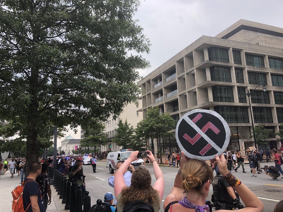 Counterprotesters walk in front of the group of Unite The Right protesters near the White House. They are mostly surrounded by D.C. Police. (WTOP/Max Smith)