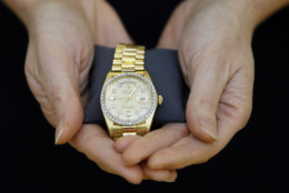 A Christie's specialist displays a Rolex watch given to Elvis Presley by his manager for Christmas in 1976, during a photocall at the auction rooms in London, Friday, Nov. 23, 2012. The watch estimated at 6,000- 8,000 pounds (9,500- 12,750 US Dollars) will go on sale in the Pop Culture auction on Nov. 29 in London. (AP Photo/Kirsty Wigglesworth)