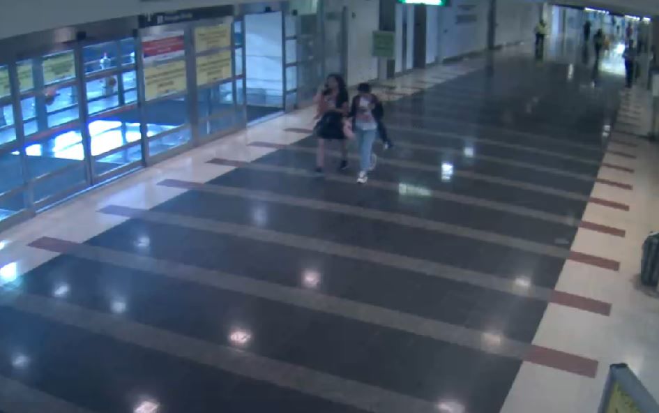 This shot shows the child and female suspect walking through the baggage/arrival area. (Courtesy Metropolitan Washington Airports Authority)