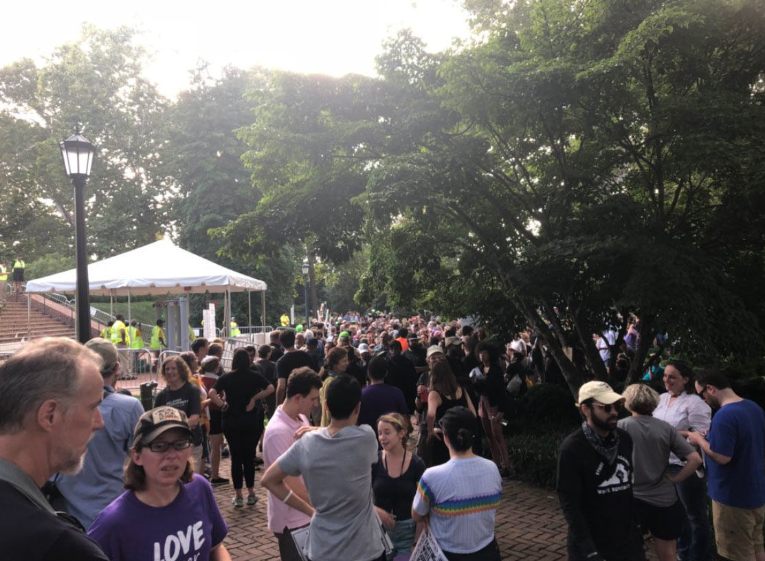 People gather outside the fenced off area of the rotunda at the University of  Virginia on Saturday, Aug. 11, 2018, during a student-led protest against the university and white supremacy. (WTOP/Max Smith)