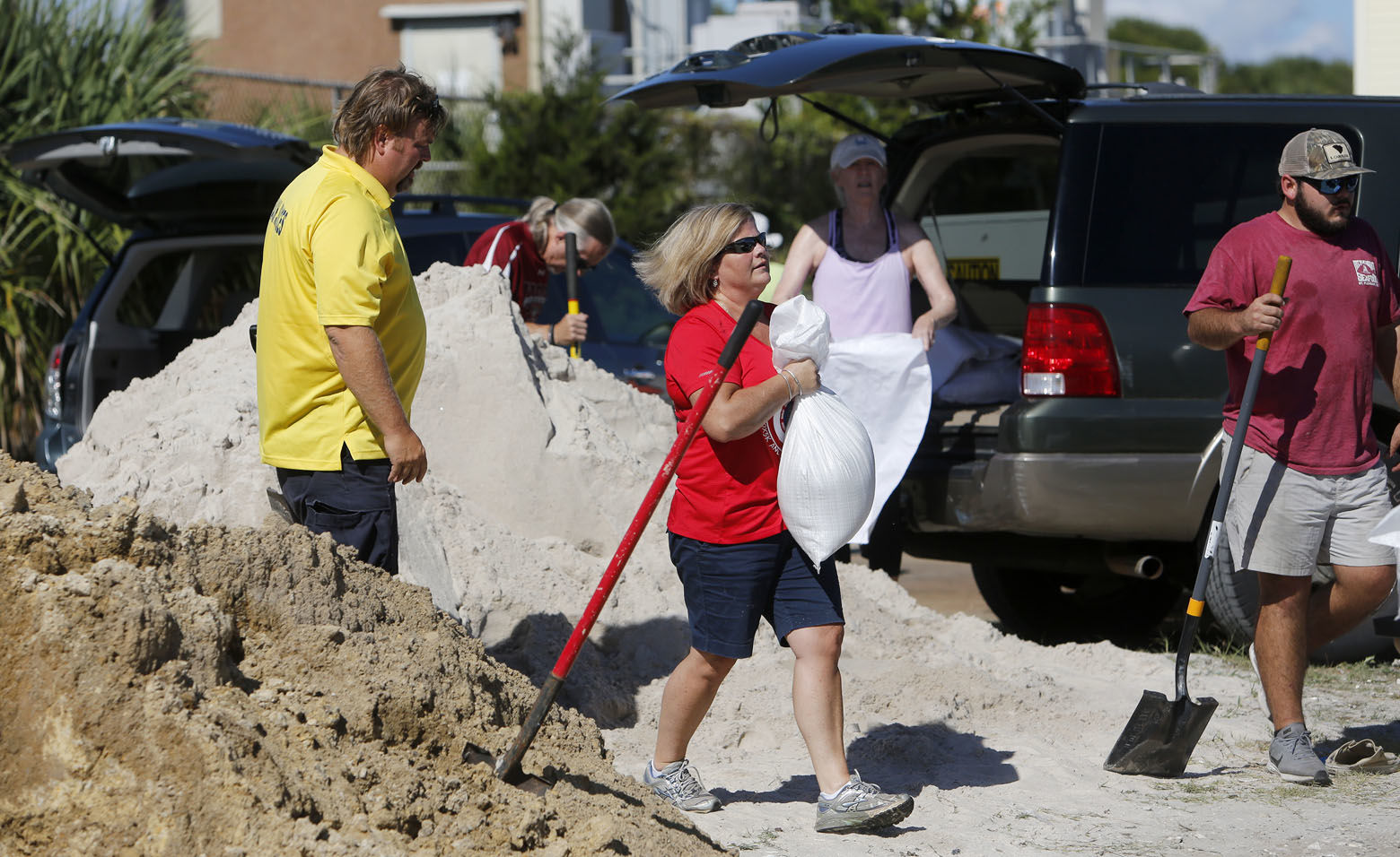 Residents of the Isle of Palms, S.C., fill sand bags at the Isle of Palms municipal lot where the city was giving away free sand in preparation for Hurricane Florence at the Isle of Palms S.C., Monday, Sept. 10, 2018. (AP Photo/Mic Smith)