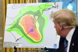 President Donald Trump looks at a chart showing potential rainfall totals from Hurricane Florence during a briefing in the Oval Office of the White House in Washington, Tuesday, Sept. 11, 2018. (AP Photo/Susan Walsh)
