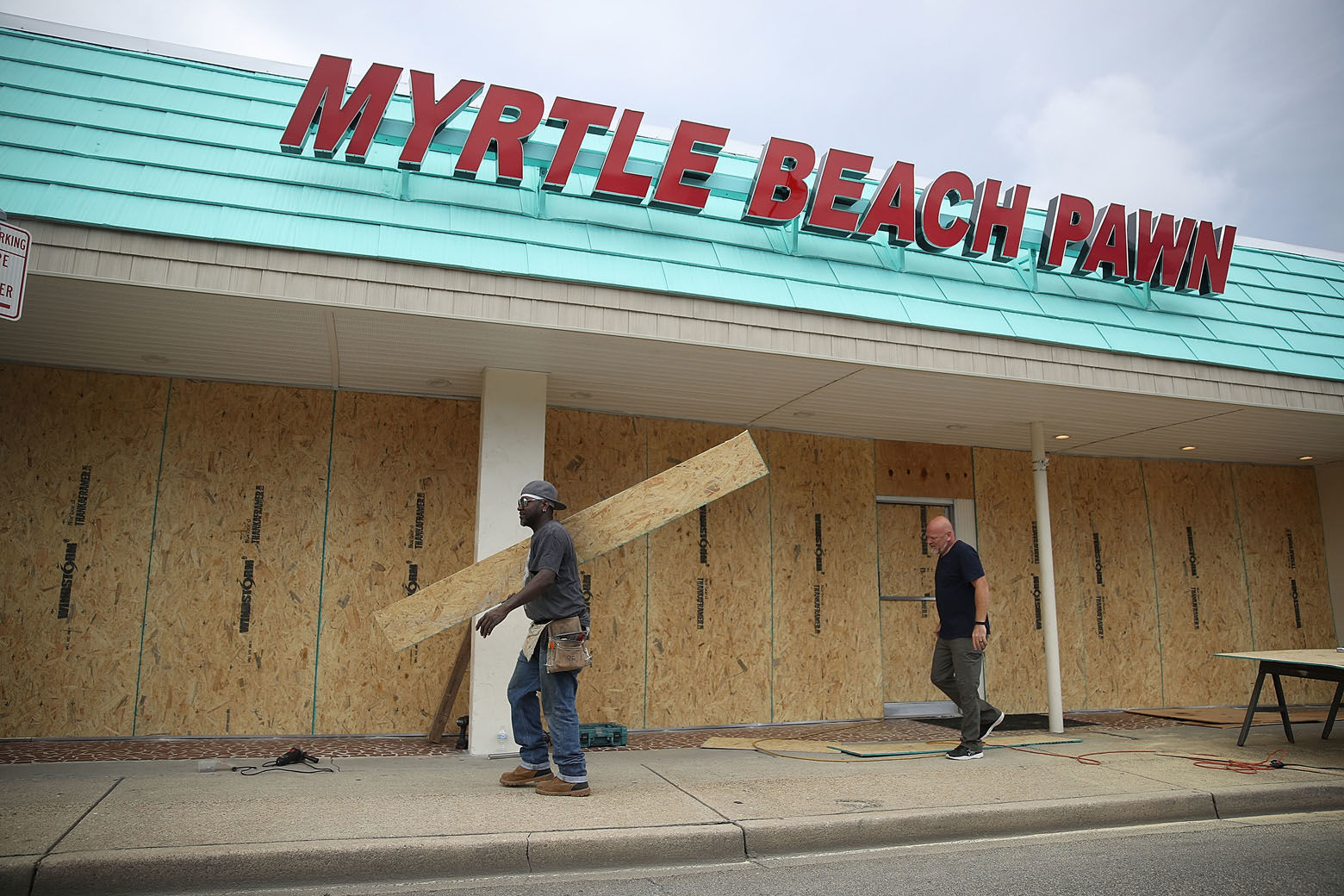 MYRTLE BEACH, SC - SEPTEMBER 11:  Jeff Bryant (L) and James Evans board the windows of a business ahead of the arrival of Hurricane Florence on September 11, 2018 in Myrtle Beach, South Carolina. Florence is expected to make landfall by late Thursday to near Category 5 strength along the Virginia, North Carolina and South Carolina coastline.  (Photo by Joe Raedle/Getty Images)